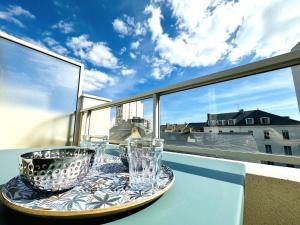 bandeja con vasos en una mesa en el balcón en Appartement rénové avec goût et idéalement situé à deux pas du remblai, en Les Sables-dʼOlonne