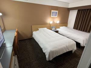 三岛市Hotel Alpha-One Mishima的一间有两张床和一台平板电视的酒店房间
