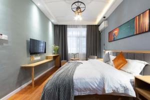 a bedroom with a bed and a flat screen tv at Hotel California Zhangjiajie in Zhangjiajie
