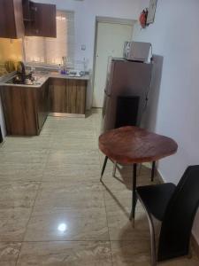eine Küche mit einem Holztisch und einem Kühlschrank in der Unterkunft KINGS AVENUE SERVICE APARTMENTS in Lagos