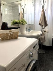 a washing machine in a bathroom with a sink at Rosy's House in Chania