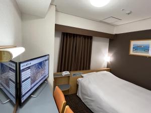 een hotelkamer met een bed en een flatscreen-tv bij Hotel Alpha-One Mishima in Mishima