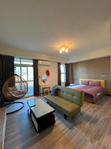 una camera con letto e divano, un letto e un tavolo di Holiday Homestay a Chishang