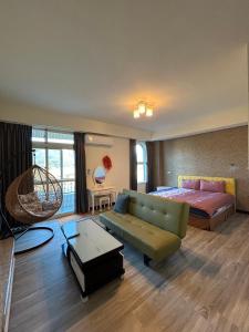 um quarto com uma cama, um sofá, uma cama e uma mesa em Holiday Homestay em Chishang