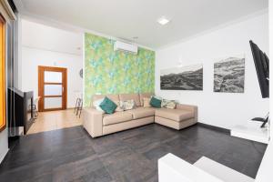 ein Wohnzimmer mit Sofa und Fernseher in der Unterkunft Villa Ariel in Playa Blanca