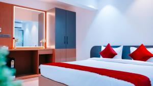 a bedroom with a bed with red pillows and a mirror at Hsquare Hotel Andheri West in Mumbai