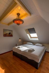 a bedroom with a large bed in a attic at Boerderijwoning De Florijn in Oosterend