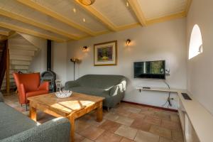 a living room with couches and a table and a tv at Boerderijwoning De Florijn in Oosterend
