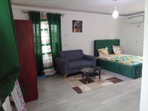a living room with a couch and a chair at Makeena Berry Cosy Mboa - OLYMPE in Douala