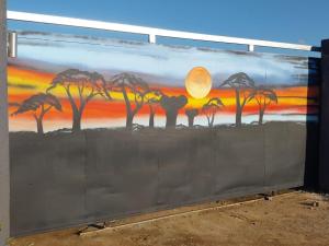 a mural of palm trees on a wall at MKHUZE INN in Mkuze
