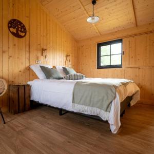 a bedroom with a large bed in a wooden room at Ecau Lodge - Logement insolite à 30km de Pairi Daiza in Écaussinnes-dʼEnghien