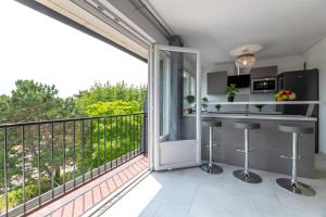een keuken met een balkon met een aanrecht en krukken bij Appartement du Blanchet très agréable in Louviers