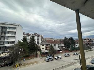 una vista de una ciudad con coches aparcados en una calle en NALTIS APARTMENTS en Gjakove