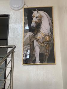a picture of a white horse on a wall at Golden Horse Hotel in Taldykorgan