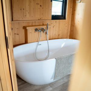 a bath tub in a tiny house bathroom at Ecau Lodge - Logement insolite à 30km de Pairi Daiza in Écaussinnes-dʼEnghien