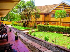 a building with a patio with a yard with benches at Explorers Hub in Kampala