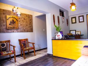 a kitchen with a yellow counter and two chairs at Explorers Hub in Kampala
