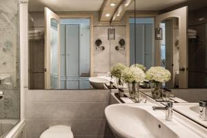 a bathroom with two sinks and two mirrors at Corinthia Palace Malta in Attard