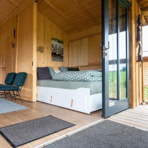 1 dormitorio con 1 cama y puerta corredera de cristal en Ecau Lodge - Logement insolite à 30km de Pairi Daiza, en Écaussinnes-dʼEnghien