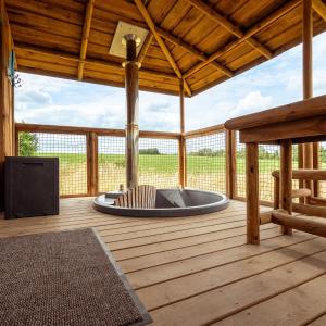 porche con bañera de hidromasaje en una terraza de madera en Ecau Lodge - Logement insolite à 30km de Pairi Daiza en Écaussinnes-dʼEnghien