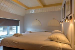 a bedroom with a large bed with a window at Boerderijwoning De Florijn in Oosterend