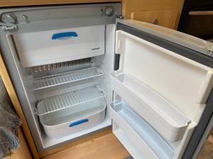um frigorífico vazio com a porta aberta numa cozinha em Cosy Caravan on Luxury Campsite em Hulme End