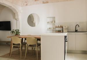 a kitchen and dining room with a table and chairs at MAJA Ostuni Centro - Luxury Apartment in Ostuni