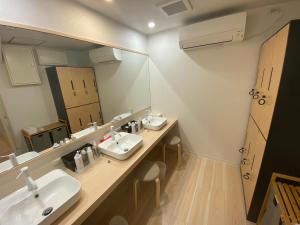 a bathroom with two sinks and a large mirror at The Toya in Lake Toya