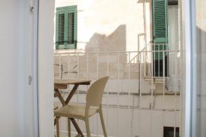 a table and a chair on a balcony at MAJA Ostuni Centro - Luxury Apartment in Ostuni
