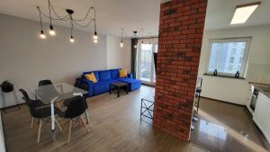 a living room with a blue couch and a brick wall at Angielska 96 in Gdańsk