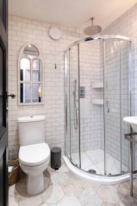 a bathroom with a toilet and a glass shower at Veeve - Bloomsbury Culture in London