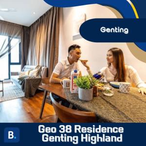 un hombre y una mujer sentados en una mesa en una sala de estar en Geo 38 Residence Genting Highland, en Genting Highlands
