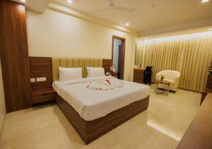 a bedroom with a bed and a desk and a chair at Meghalaya Hotel in Visakhapatnam