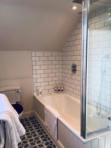 a bathroom with a tub and a toilet at Luxury Cottage with Garden in Bredon