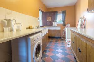 a kitchen with a washer and dryer in it at Brynonnen Llangrannog in Llanllwchaiarn +10 photos