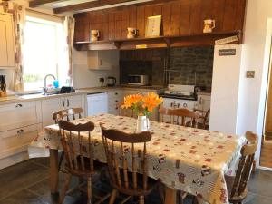 a kitchen with a table with a vase of flowers on it at Brynonnen Nanternis in Llanllwchaiarn