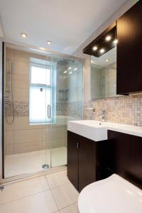 a bathroom with a sink and a glass shower at Veeve - Parkside Purity in London