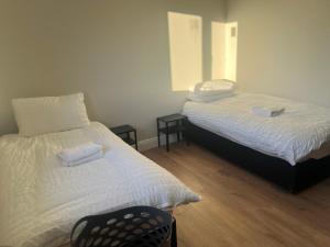 Un dormitorio con 2 camas y una silla. en Willow Valley en Monaghan