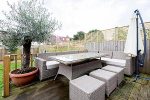 a table and chairs and a tree on a deck at Veeve - Parkside Purity in London