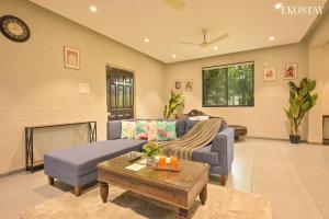 a living room with a blue couch and a fireplace at EKO STAY- Brickstone Villa in Igatpuri