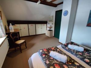 1 dormitorio con cama, escritorio y silla en The Horst cottage en Holsbeek