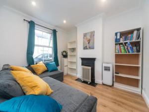 - un salon avec un canapé et une cheminée dans l'établissement Pass the Keys Modernised family-friendly cottage, à Surbiton