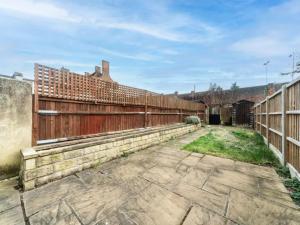 une vieille clôture et un chemin en briques dans une cour dans l'établissement Pass the Keys Modernised family-friendly cottage, à Surbiton