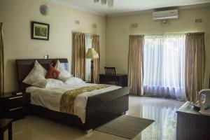 A bed or beds in a room at Waterfalls hotel (Lusaka)