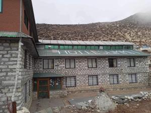 um edifício de tijolos com um sinal que não lê yetarius em Hotel Summit em Dingboche