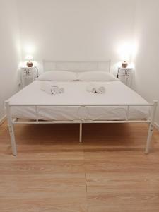 een wit bed in een kamer met 2 nachtkastjes bij Maride Holiday in Noto
