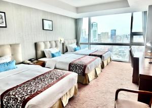 烏蘭巴托的住宿－藍天大廈酒店，酒店客房设有三张床和大窗户