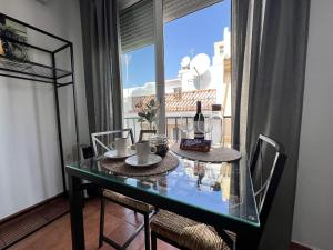 comedor con mesa de cristal y ventana en RC La Carihuela by Beehive Vacances, en Torremolinos