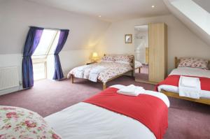 a bedroom with two beds and a mirror at Ettrick View in Selkirk