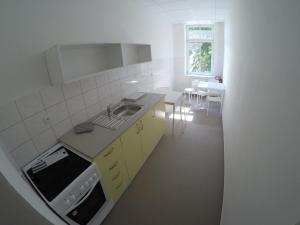 a white kitchen with a sink and a stove at Centrum Ubytování Břeclav in Břeclav